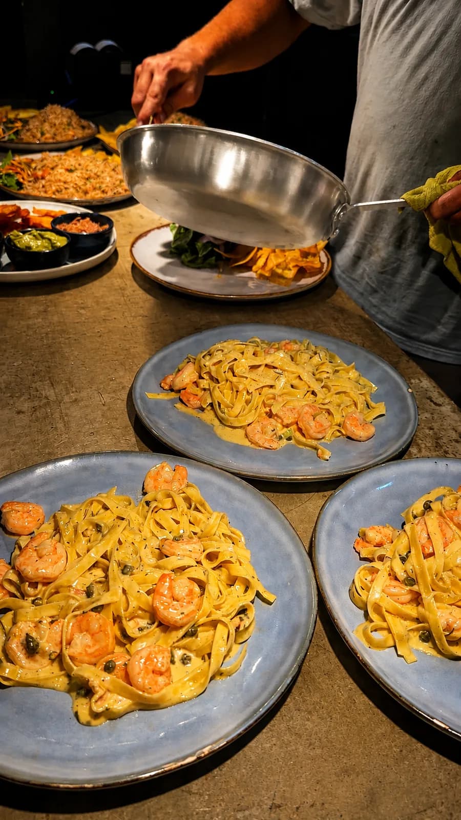 Pasta con camarones servida en varios platos